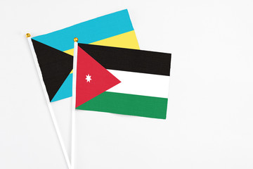 Jordan and Bahamas stick flags on white background. High quality fabric, miniature national flag. Peaceful global concept.White floor for copy space.