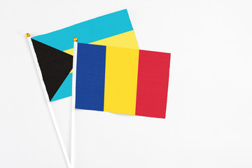 Romania and Bahamas stick flags on white background. High quality fabric, miniature national flag. Peaceful global concept.White floor for copy space.