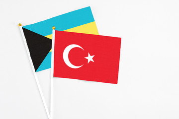 Turkey and Bahamas stick flags on white background. High quality fabric, miniature national flag. Peaceful global concept.White floor for copy space.