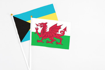 Wales and Bahamas stick flags on white background. High quality fabric, miniature national flag. Peaceful global concept.White floor for copy space.
