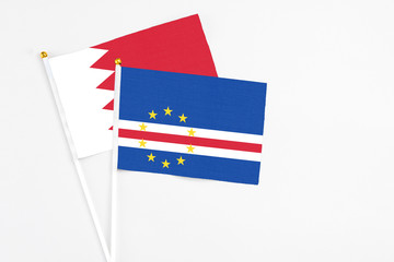 Cape Verde and Bahrain stick flags on white background. High quality fabric, miniature national flag. Peaceful global concept.White floor for copy space.