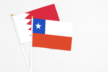 Chile and Bahrain stick flags on white background. High quality fabric, miniature national flag. Peaceful global concept.White floor for copy space.