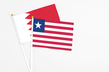 Liberia and Bahrain stick flags on white background. High quality fabric, miniature national flag....