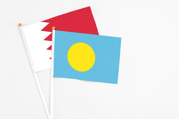 Palau and Bahrain stick flags on white background. High quality fabric, miniature national flag....