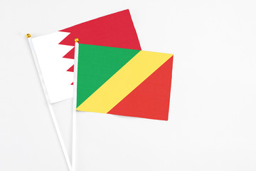 Republic Of The Congo and Bahrain stick flags on white background. High quality fabric, miniature national flag. Peaceful global concept.White floor for copy space.