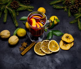 Christmas mulled wine with spices and oranges and tangerines on a wooden rustic table. Traditional...