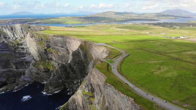 The spectacular Kerry Cliffs are located on the Skellig Coast in County Kerry in Ireland. The town of Portmagee and Valentia Island can be seen in the background.