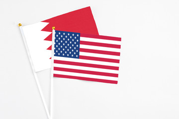 United States and Bahrain stick flags on white background. High quality fabric, miniature national flag. Peaceful global concept.White floor for copy space.