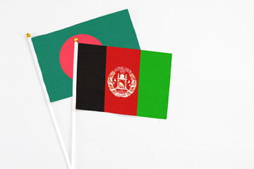 Afghanistan and Bangladesh stick flags on white background. High quality fabric, miniature national flag. Peaceful global concept.White floor for copy space.