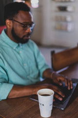 man working on laptop in cafe