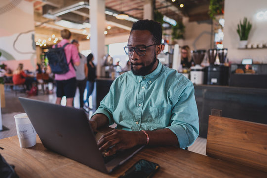 man working on tablet computer in cafe