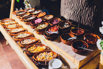 Salad bar with various fresh vegetables and other foods.