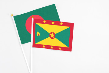 Grenada and Bangladesh stick flags on white background. High quality fabric, miniature national flag. Peaceful global concept.White floor for copy space.