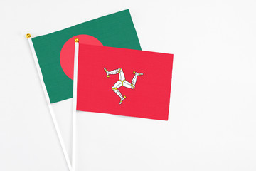 Isle Of Man and Bangladesh stick flags on white background. High quality fabric, miniature national flag. Peaceful global concept.White floor for copy space.