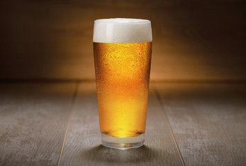 Beautiful colorful glass of IPA beer served on retro wooden surface, ale, golden, belgian, american...