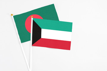 Kuwait and Bangladesh stick flags on white background. High quality fabric, miniature national flag. Peaceful global concept.White floor for copy space.