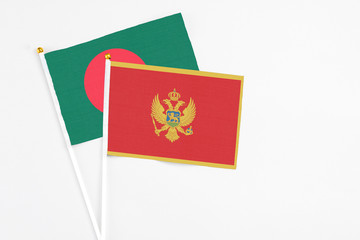 Montenegro and Bangladesh stick flags on white background. High quality fabric, miniature national flag. Peaceful global concept.White floor for copy space.