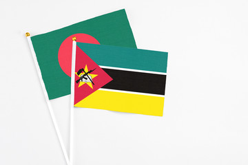Mozambique and Bangladesh stick flags on white background. High quality fabric, miniature national...