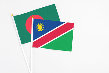 Namibia and Bangladesh stick flags on white background. High quality fabric, miniature national flag. Peaceful global concept.White floor for copy space.