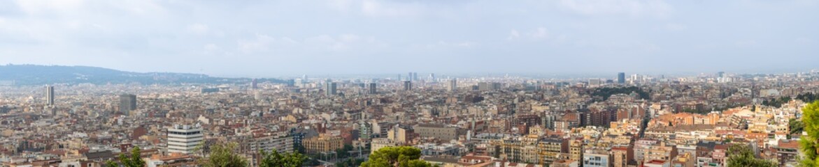 Fototapeta na wymiar Barcelona, Spain - august 2019: panoramic background of Barcelona, extra long view. A lot of building, horizon and cloudy sky. Selective soft focus. Blurred background