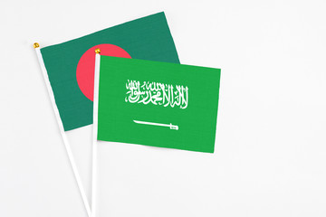 Saudi Arabia and Bangladesh stick flags on white background. High quality fabric, miniature national flag. Peaceful global concept.White floor for copy space.