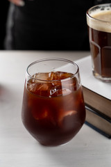 Iced coffee with cherry juice on a white table
