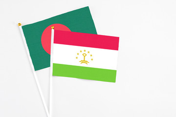 Tajikistan and Bangladesh stick flags on white background. High quality fabric, miniature national flag. Peaceful global concept.White floor for copy space.