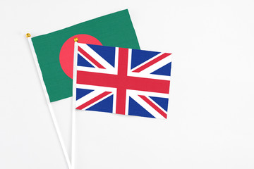 United Kingdom and Bangladesh stick flags on white background. High quality fabric, miniature national flag. Peaceful global concept.White floor for copy space.