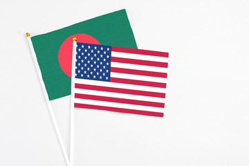 United States and Bangladesh stick flags on white background. High quality fabric, miniature national flag. Peaceful global concept.White floor for copy space.