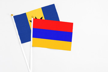 Armenia and Barbados stick flags on white background. High quality fabric, miniature national flag. Peaceful global concept.White floor for copy space.