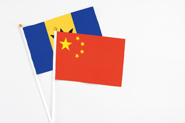 China and Barbados stick flags on white background. High quality fabric, miniature national flag. Peaceful global concept.White floor for copy space.