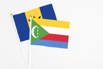 Comoros and Barbados stick flags on white background. High quality fabric, miniature national flag....