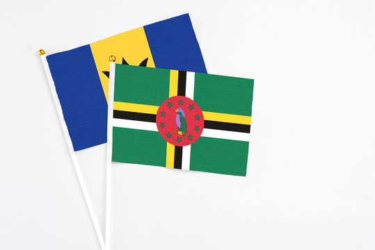 Dominica and Barbados stick flags on white background. High quality fabric, miniature national flag. Peaceful global concept.White floor for copy space.