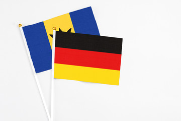 Germany and Barbados stick flags on white background. High quality fabric, miniature national flag. Peaceful global concept.White floor for copy space.