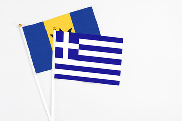 Greece and Barbados stick flags on white background. High quality fabric, miniature national flag. Peaceful global concept.White floor for copy space.