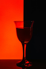 A glass of wine with rose wine stands on a table.