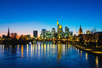 Fototapeta na wymiar Skyline of Frankfurt, Germany in the sunset with famous illuminated skyscrapers
