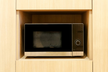 kitchen microwave on wooden shelf