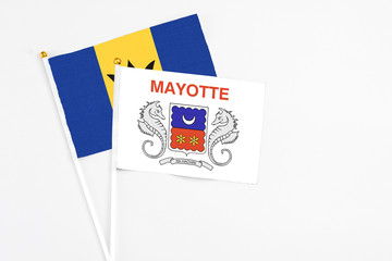Mayotte and Barbados stick flags on white background. High quality fabric, miniature national flag. Peaceful global concept.White floor for copy space.