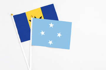 Micronesia and Barbados stick flags on white background. High quality fabric, miniature national flag. Peaceful global concept.White floor for copy space.