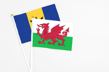 Wales and Barbados stick flags on white background. High quality fabric, miniature national flag. Peaceful global concept.White floor for copy space.