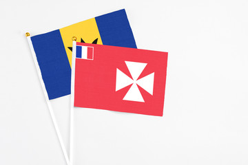 Wallis And Futuna and Barbados stick flags on white background. High quality fabric, miniature national flag. Peaceful global concept.White floor for copy space.