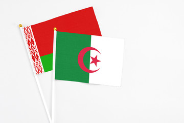 Algeria and Belarus stick flags on white background. High quality fabric, miniature national flag. Peaceful global concept.White floor for copy space.