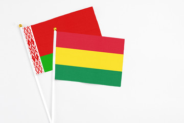Bolivia and Belarus stick flags on white background. High quality fabric, miniature national flag. Peaceful global concept.White floor for copy space.