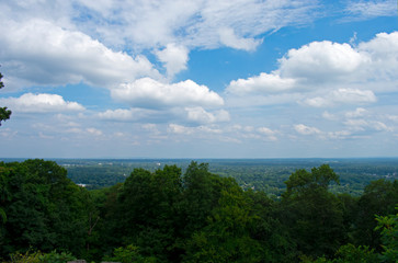 Washington Rock Historic area in New Jersey's Watchung Mountains with trees, rocky paths, cloud filled skies, and panoramic views of the surrounding area -02