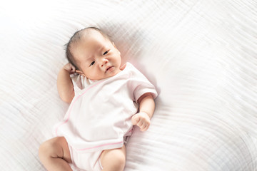 Happy Adorable baby girl sleeping in crib. Small kid having day nap in parents bed