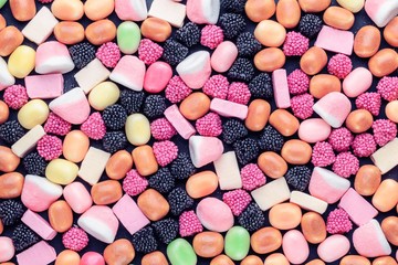 background of multi-colored candies on a dark background with copy space