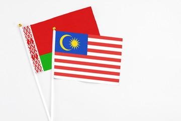 Malaysia and Belarus stick flags on white background. High quality fabric, miniature national flag. Peaceful global concept.White floor for copy space.