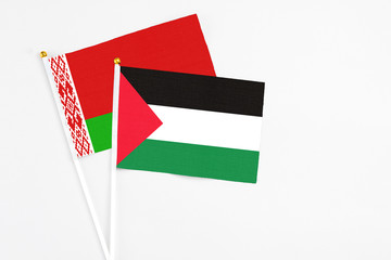 Palestine and Belarus stick flags on white background. High quality fabric, miniature national flag. Peaceful global concept.White floor for copy space.