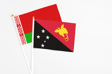 Papua New Guinea and Belarus stick flags on white background. High quality fabric, miniature national flag. Peaceful global concept.White floor for copy space.